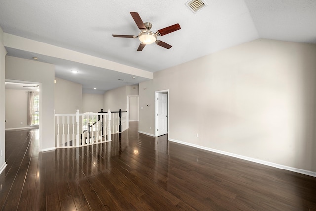 spare room with lofted ceiling, baseboards, visible vents, and wood finished floors