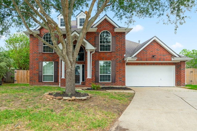 traditional home featuring concrete driveway, brick siding, an attached garage, and fence