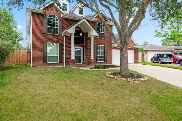 traditional-style home with concrete driveway, an attached garage, fence, a front lawn, and brick siding