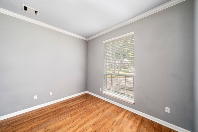 unfurnished room featuring visible vents, crown molding, light wood-style flooring, and baseboards