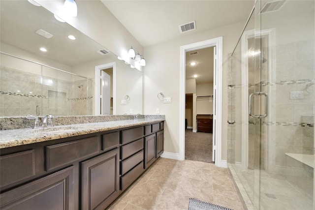 full bathroom featuring double vanity, a sink, visible vents, and a shower stall