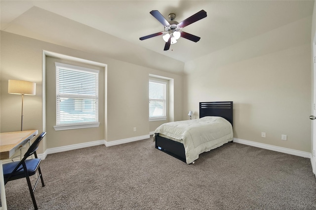 bedroom with dark colored carpet, ceiling fan, lofted ceiling, and baseboards