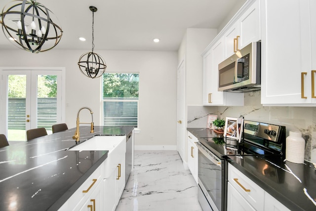 kitchen featuring appliances with stainless steel finishes, marble finish floor, plenty of natural light, and decorative backsplash