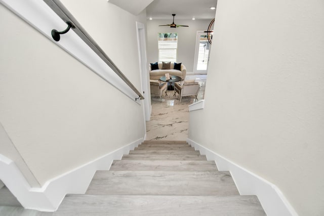 stairway with recessed lighting, a ceiling fan, and wood finished floors