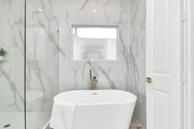 bathroom featuring a freestanding tub and walk in shower