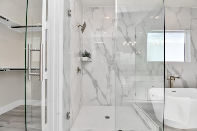 full bathroom featuring wood finished floors and a marble finish shower