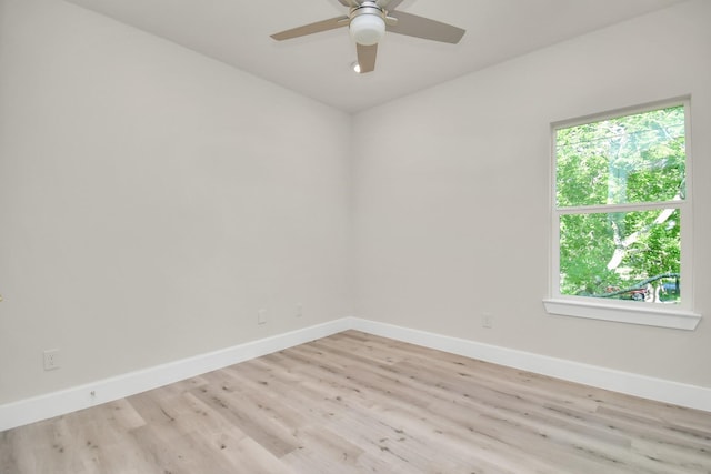 spare room with ceiling fan, light wood-style flooring, and baseboards