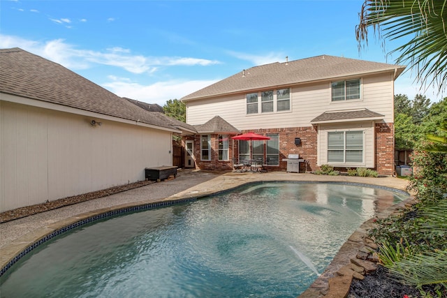 outdoor pool with area for grilling and a patio