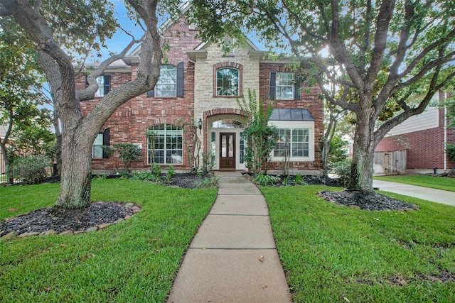 view of front of house with a front yard and brick siding