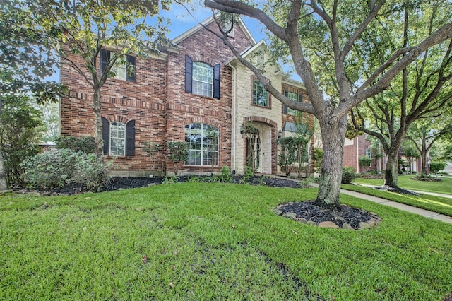 traditional-style home featuring brick siding and a front yard