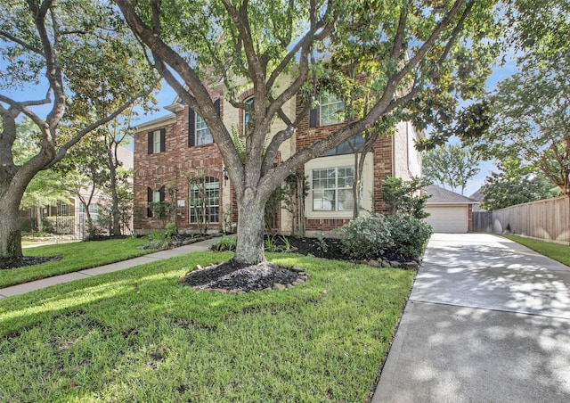 view of front of house with a front yard, brick siding, and fence