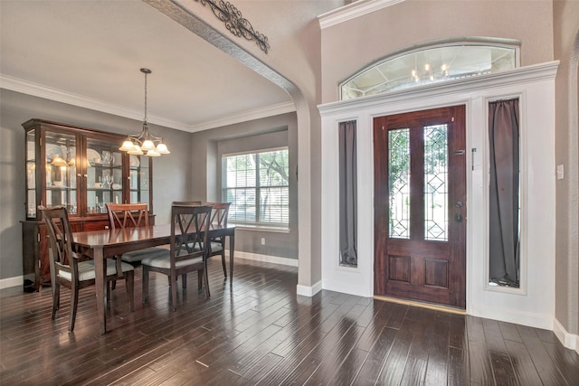 entrance foyer with ornamental molding, dark wood-style flooring, baseboards, and an inviting chandelier