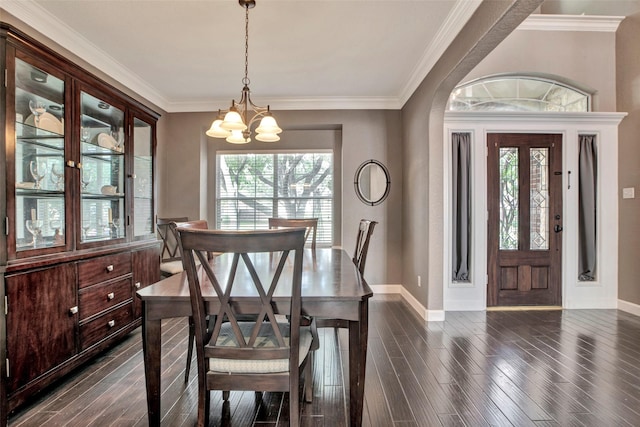 dining room with a chandelier, dark wood-type flooring, plenty of natural light, and crown molding