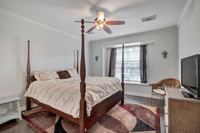 bedroom with dark wood-type flooring, visible vents, crown molding, and baseboards