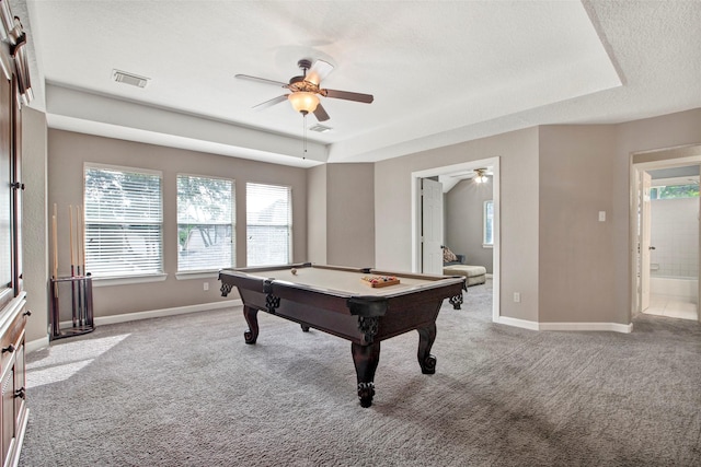 rec room with light carpet, a textured ceiling, visible vents, and a tray ceiling