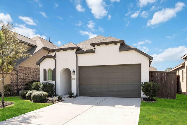 view of front of home with driveway, stucco siding, an attached garage, and a front yard