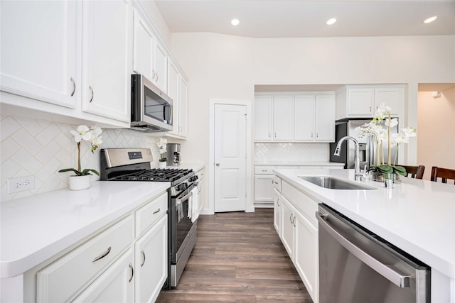 kitchen featuring white cabinets, stainless steel appliances, a sink, and light countertops