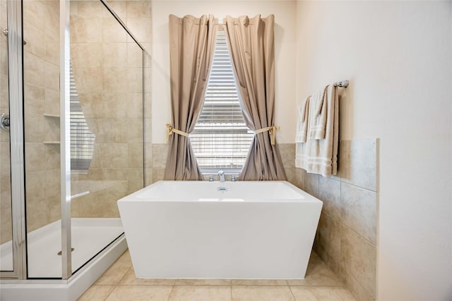 full bathroom featuring tile patterned flooring, a soaking tub, a shower stall, and tile walls