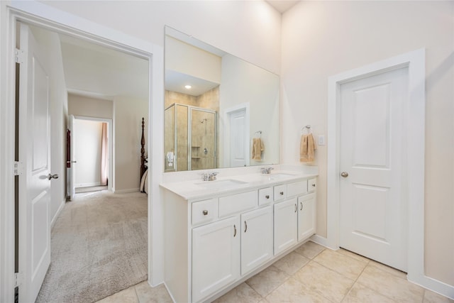 full bathroom featuring double vanity, a stall shower, tile patterned flooring, and a sink