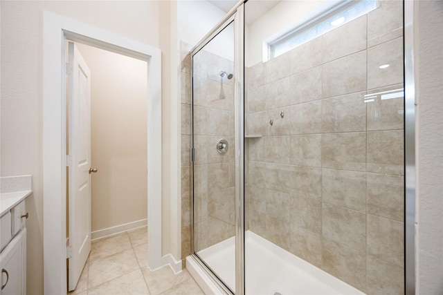 bathroom featuring tile patterned flooring, a shower stall, and vanity