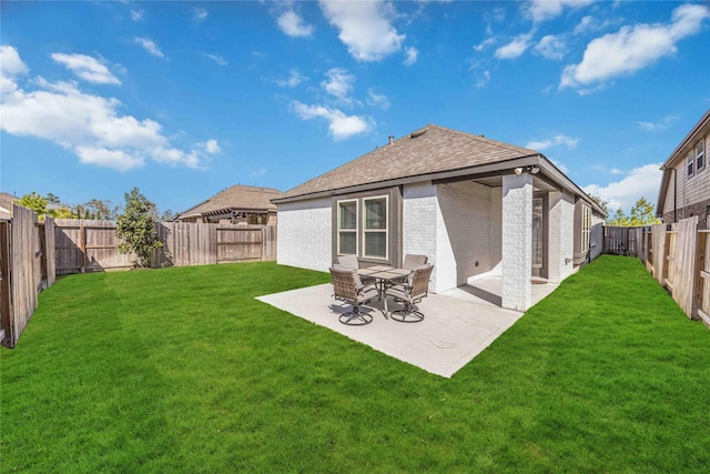 back of property with a patio, a fenced backyard, brick siding, a lawn, and roof with shingles