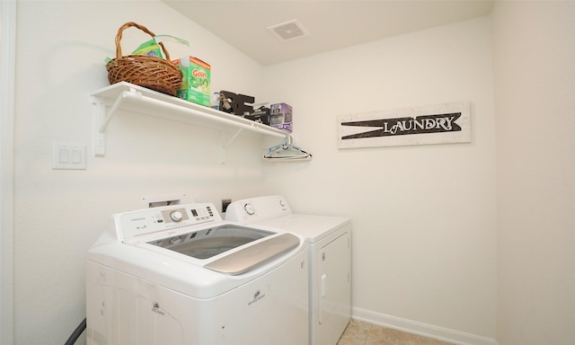 washroom featuring light tile patterned floors, visible vents, washing machine and dryer, laundry area, and baseboards