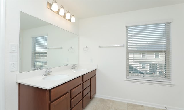 full bathroom with a sink, baseboards, and double vanity