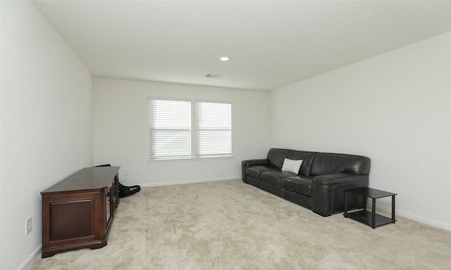 sitting room with baseboards, visible vents, and light colored carpet