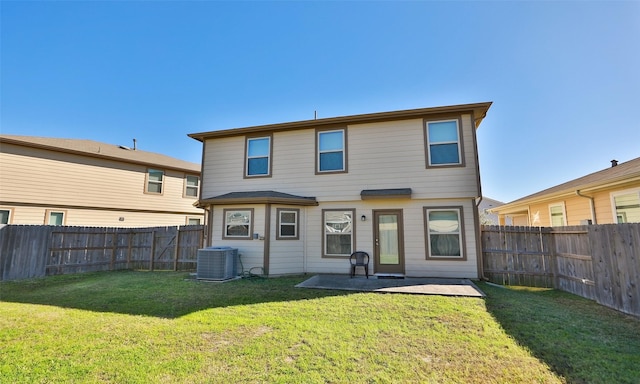 back of property featuring a fenced backyard, a lawn, central AC, and a patio