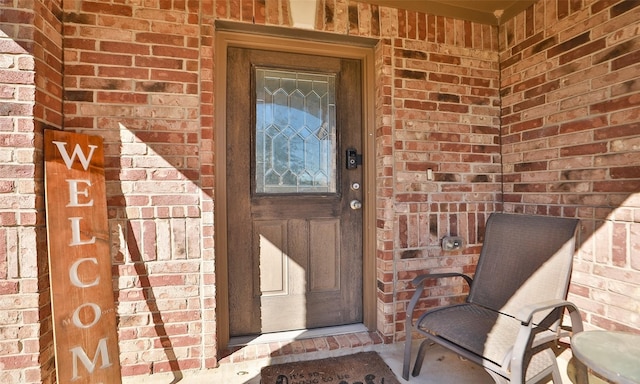 doorway to property with brick siding