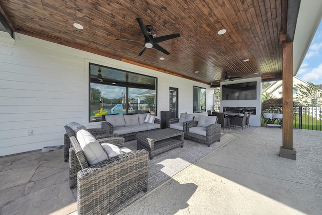 view of patio with ceiling fan, fence, and an outdoor living space