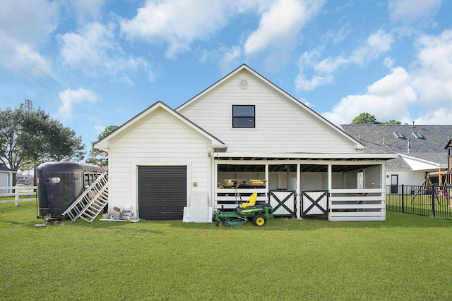 back of house with an outdoor structure, fence, and a lawn