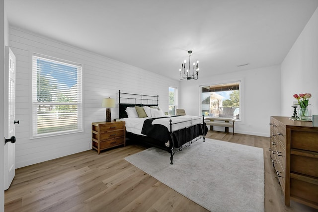 bedroom featuring light wood-type flooring and a notable chandelier