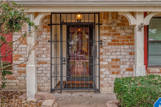 entrance to property featuring brick siding