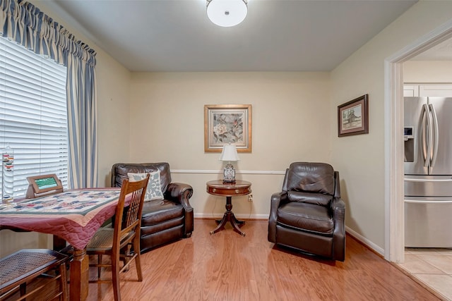 living area with light wood-style floors and baseboards