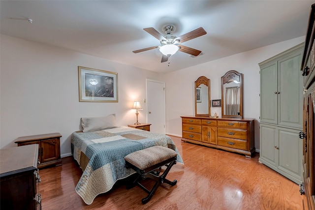 bedroom with light wood-type flooring, ceiling fan, and baseboards