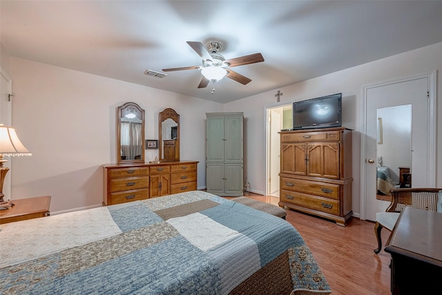 bedroom featuring light wood-style floors, baseboards, visible vents, and a ceiling fan