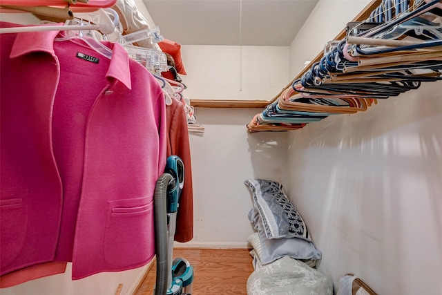 walk in closet with wood finished floors