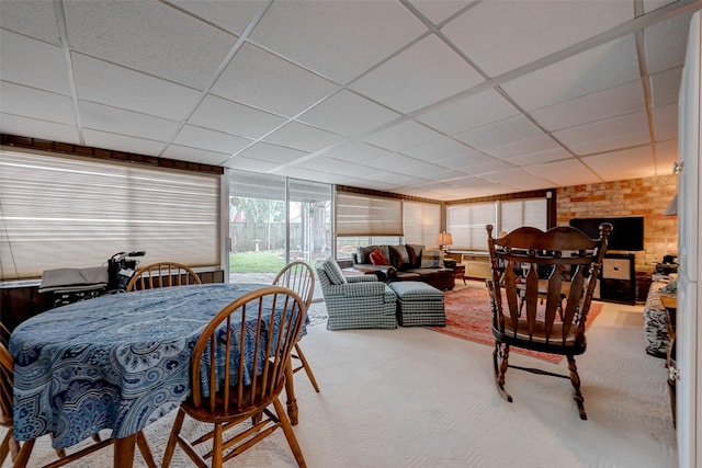 carpeted dining room with a drop ceiling