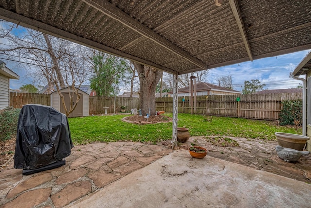 view of patio / terrace featuring a fenced backyard, an outdoor structure, grilling area, and a shed