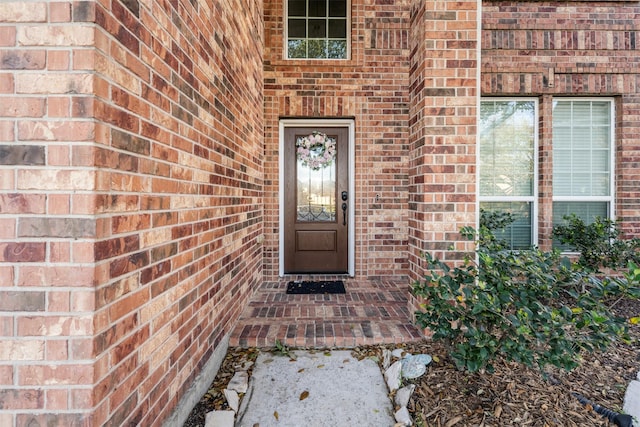 doorway to property featuring brick siding