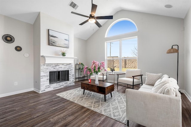 living area featuring a stone fireplace, wood finished floors, visible vents, and baseboards