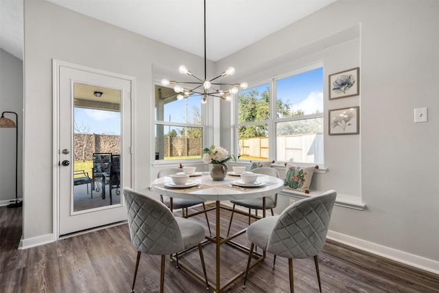 dining room with a notable chandelier, baseboards, and wood finished floors