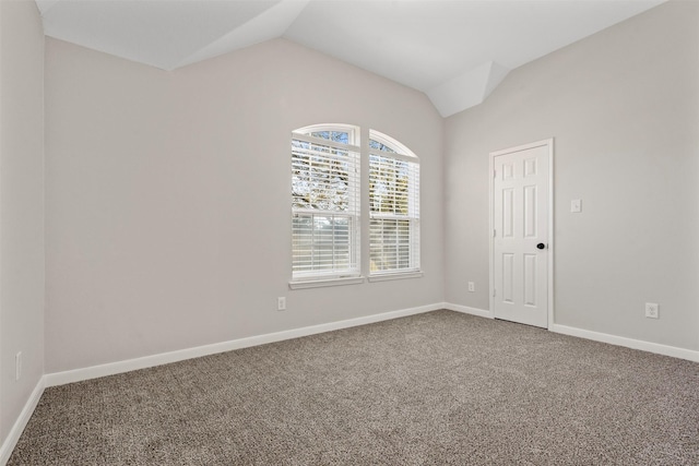 carpeted empty room with lofted ceiling and baseboards