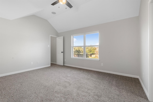 carpeted spare room with a ceiling fan, vaulted ceiling, and baseboards