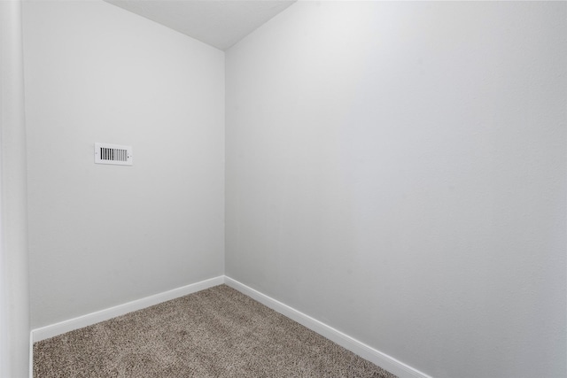 carpeted spare room with visible vents and baseboards