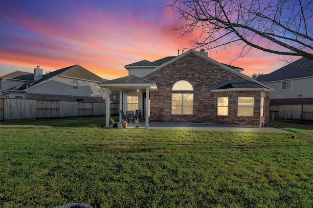 back of house with brick siding, a patio area, and a fenced backyard