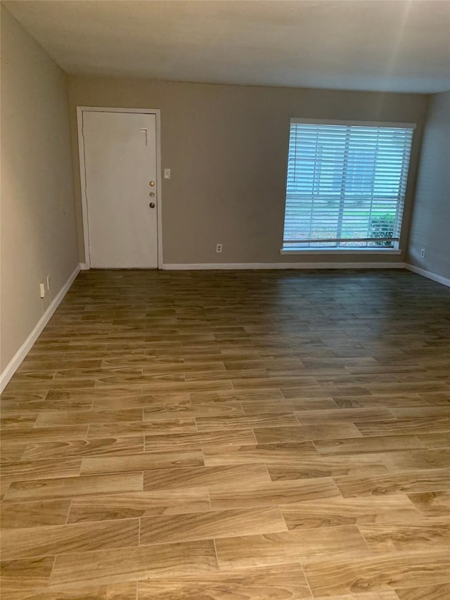 unfurnished room featuring baseboards and wood finished floors