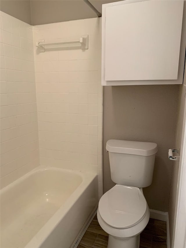 bathroom with bathtub / shower combination, baseboards, toilet, and wood finished floors