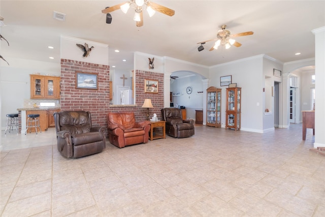 living area featuring arched walkways, visible vents, baseboards, a ceiling fan, and ornamental molding